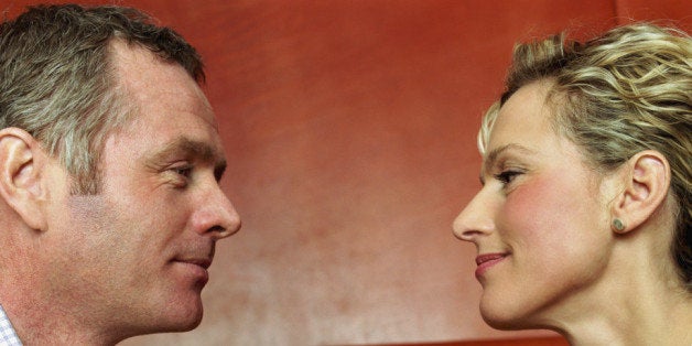 Couple sitting face-to-face at restaurant table, holding hands