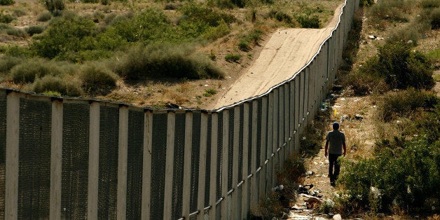 CIUDAD JUAREZ, CHIHUAHUA - JUNE 29: A man walks along the border fence between the U.S. and Mexico on June 29, 2007 in the Anapra area of Ciudad Juarez, Mexico. This area is a popular crossing spot for immigrants to ilegally cross into the United States because houses are close to the border on the south side and the highway is close to the north side. (Photo by Chip Somodevilla/Getty Images)