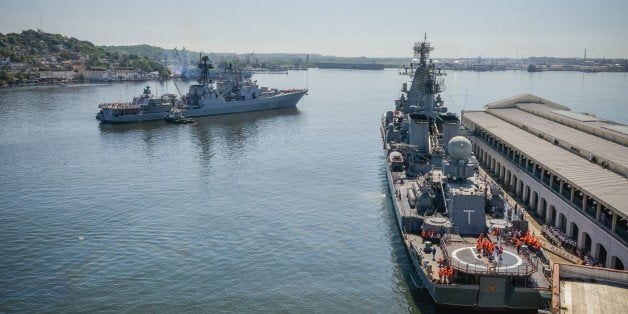 Cubans watch as the 'Moskva' Russian guide missile cruiser (R) and destroyer ' Vice Admiral Kulakov' (L) moor at Havana's harbour, on August 3, 2013. The vessel is part of a three-ship group in official visit to Cuba. AFP PHOTO/Adalberto ROQUE (Photo credit should read ADALBERTO ROQUE/AFP/Getty Images)