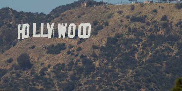 LOS ANGELES, CA - MARCH 29: Tourists line up on a hilltop to take photos with the Hollywood sign in the background at Gri