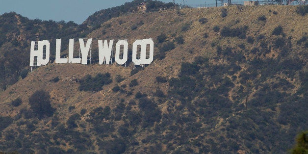 LOS ANGELES, CA - MARCH 29: Tourists line up on a hilltop to take photos with the Hollywood sign in the background at Griffith Park March 29, 2015 in Los Angeles, California. Los Angeles City Parks and Recreation recently opened up Mount Hollywood Drive to let people get up close to take pictures of the Hollywood sign. This came in response to people in nearby Beachwood Canyon who complained of too much tourist traffic coming through their neighborhood. But now the same thing is happening in Griffith Park. (Allen J. Schaben/Los Angeles Times via Getty Images)