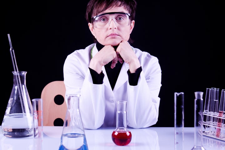 Female Scientist Portrait between flasks and fluids in lab