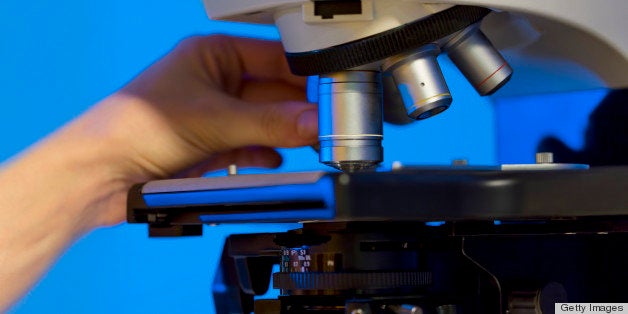 Scientist using microscope