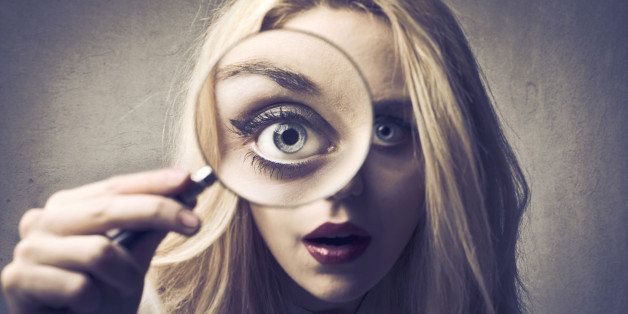 Beautiful woman looking through a magnifying glass