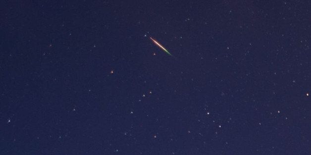 SALTBURN, UNITED KINGDOM - AUGUST 13: A brightly coloured meteor can be seen as it streaks across the early morning sky on August 13, 2013 over Saltburn, United Kingdom. The Perseid Meteor shower is visible from mid-july each year with peak activity being between the 9th and 14th of August. During the peak, the rate of meteors can reach 60 or more per hour. They can be seen all across the sky as they gradually fall away from the tail of the Swift-Tuttle comet. (Photo by Ian Forsyth/Getty Images)