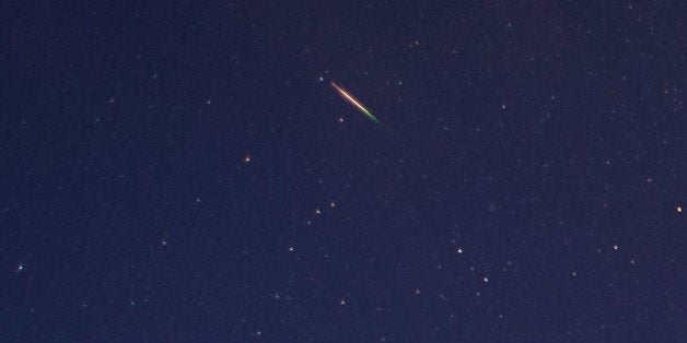 SALTBURN, UNITED KINGDOM - AUGUST 13: A brightly coloured meteor can be seen as it streaks across the early morning sky on August 13, 2013 over Saltburn, United Kingdom. The Perseid Meteor shower is visible from mid-july each year with peak activity being between the 9th and 14th of August. During the peak, the rate of meteors can reach 60 or more per hour. They can be seen all across the sky as they gradually fall away from the tail of the Swift-Tuttle comet. (Photo by Ian Forsyth/Getty Images)