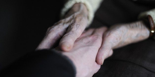 A woman, suffering from Alzheimer's desease, holds the hand of a relative on March 18, 2011 in a retirement house in Angervilliers, eastern France. AFP PHOTO / SEBASTIEN BOZON (Photo credit should read SEBASTIEN BOZON/AFP/Getty Images)