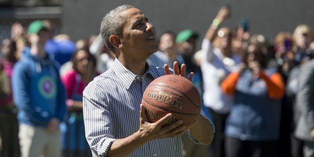 US President Barack Obama shoots a basketball during the annual White House Easter Egg Roll on the South Lawn of the White House in Washington, DC, April 21, 2014. The 126th annual White House Easter Egg Roll, the largest annual public event at the White House with more than 30,000 attendees expected, features live music, sports courts, cooking stations, storytelling and Easter egg rolling, with the theme, 'Hop into Healthy, Swing into Shape.' AFP PHOTO / Saul LOEB (Photo credit should read SAUL LOEB/AFP/Getty Images)