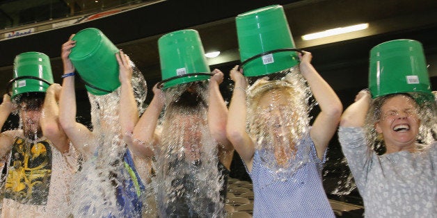 MELBOURNE, AUSTRALIA - AUGUST 22: Participants tip buckets of ice water over their heads as they take part in the World Record Ice Bucket Challenge at Etihad Stadium on August 22, 2014 in Melbourne, Australia. Over 700 people took part in setting the new world record. The Ice Bucket Challenge is the social media phenomenon which is helping raise awareness and money for sufferers of Motor Neurone Disease. (Photo by Scott Barbour/Getty Images)