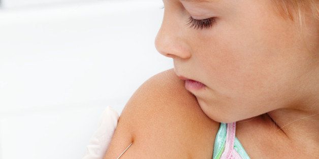 Little girl getting an injection or vaccine - closeup