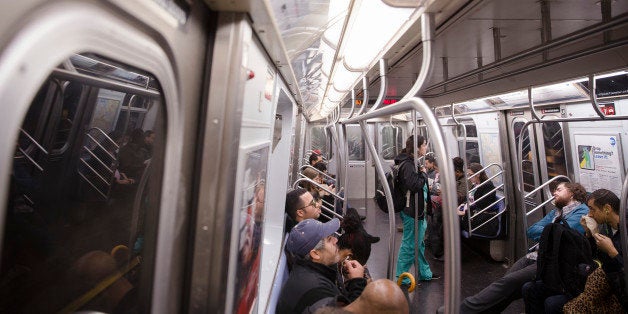 Commuters ride inside an L train subway car, Friday, Oct. 24, 2014, in New York. Craig Spencer, a Doctors Without Borders physician who tested positive for the Ebola virus after treating Ebola patients in West Africa, had taken the train after visiting a bowling alley in Williamsburg. (AP Photo/John Minchillo)