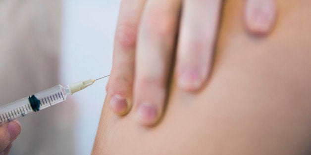 Cropped image of doctor injecting patient in clinic