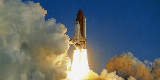 usa, florida, kennedy space centre, nasa space shuttle lifting off amidst thick white clouds of smoke and flames from rocket boosters.