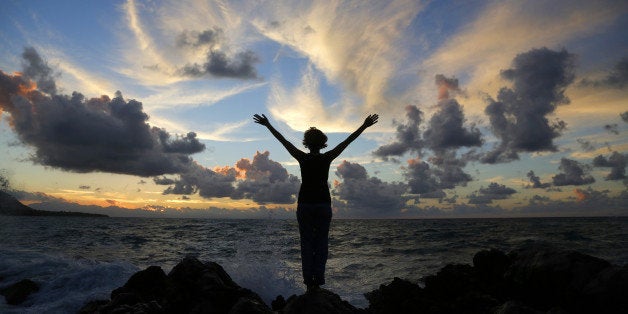 Silhouette of Caucasian woman on beach at sunset