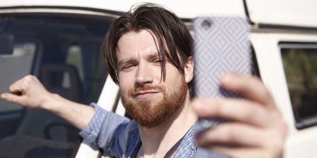 Man taking selfie in front of car