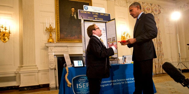 Harry Paul, 18, of Port Washington, N.Y., left, shows President Barack Obama his "growing spine implant" during Obama's tour of the White House Science Fair, Monday, March 23, 2015, at the White House in Washington. (AP Photo/Jacquelyn Martin)