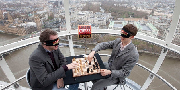 English Grand Master chess players Luke McShane (R) and Nigel Short take part in a blindfolded game of chess in a London Eye capsule, on December 7, 2009, before the start of the London Chess Classic which is the first world class chess tournament to be staged in Britain for 25 years. It will be held at London Olympia from 8-15 December and will host players from around the world. AFP PHOTO/Carl Court (Photo credit should read Carl Court/AFP/Getty Images)