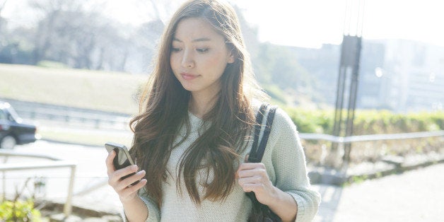 Young woman using smartphone on street