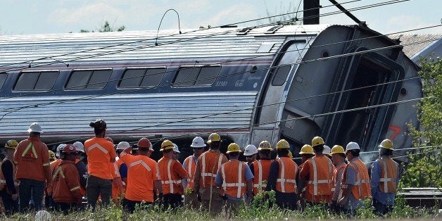 Rescuers gather around a derailed carriage of an Amtrak train in Philadelphia, Pennsylvania, on May 13, 2015. Rescuers on May 13 combed through the mangled wreckage of a derailed train in Philadelphia after an accident that left at least six dead, as the difficult search for possible survivors continued. AFP PHOTO/JEWEL SAMAD (Photo credit should read JEWEL SAMAD/AFP/Getty Images)