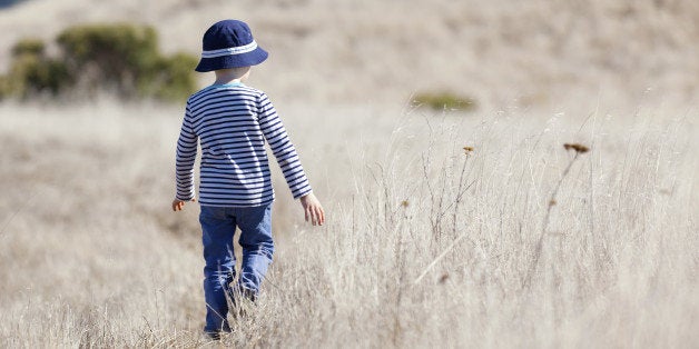 little boy enjoying beautiful weather alone outdoors