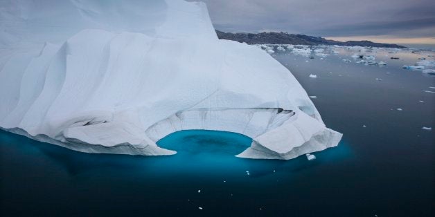 FILE - In this July 19, 2007 file photo, an iceberg is seen melting off the coast of Ammasalik, Greenland. A new assessment of climate change in the Arctic shows the ice in the region is melting faster than previously thought and sharply raises projections of global sea level rise this century. (AP Photo/John McConnico, File)