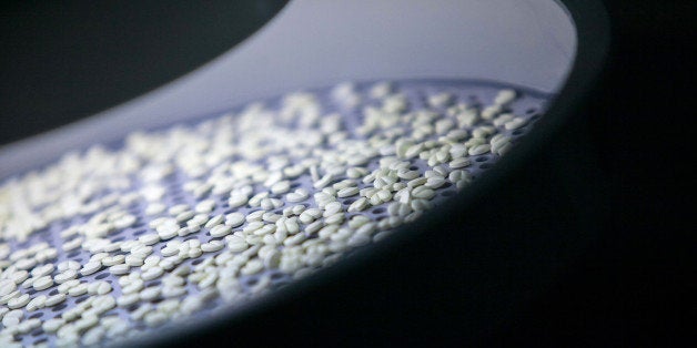 Concor blood pressure tablets sit illuminated during the film-coating process in the laboratories at the Merck KGaA headquarters in Darmstadt, Germany, on Wednesday, June 25, 2014. Merck, the maker of the Erbitux cancer drug, forecast a 'moderate increase' in sales and profit in 2014 because of the acquisition of AZ Electronic Materials SA, a chemicals supplier to the electronics industry. Photographer: Krisztian Bocsi/Bloomberg via Getty Images