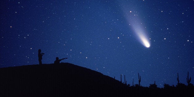 Comet Hale-Bopp is viewed by a couple on a hillside overlooking the Arizona desert.