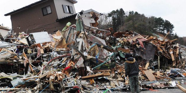 ONAGAWACHO, JAPAN - MARCH 15: A man searches the debris for his wife who was working at a power station during the earthquake March 15, 2011 in Onagawacho, Miyagi Prefecture, Japan. After a third explosion Tuesday at the Fukushima Daiichi nuclear power plant, the government is telling people living within 20 miles to stay indoors with the windows closed because of the possibility of high levels of radiation being released from the plant. (Photo by XINHUA/Gamma-Rapho via Getty Images )