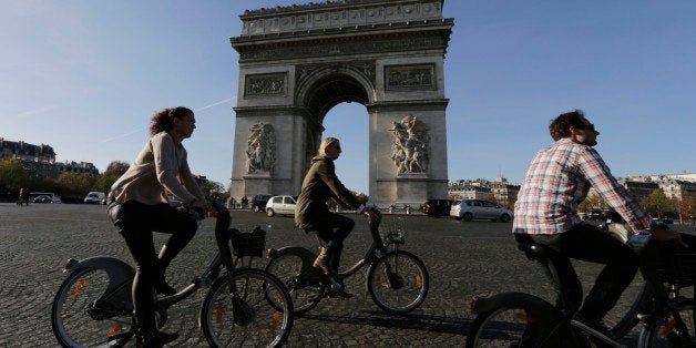 Tourists enjoy bicycle tours pass the Arch of Triumph in the Champs Elysees district of Paris, France, Sunday, Nov. 15, 2015.