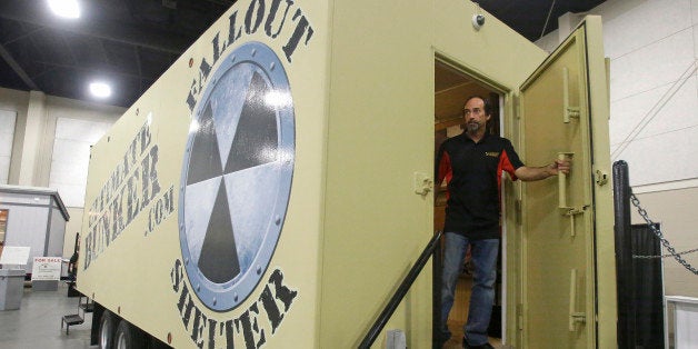 Mike Peters, with Ultimate Bunker stands at the doorway of a 100% steel underground bunker during the PrepperCon expo Friday, April 24, 2015, in Sandy, Utah. Hundreds of survivalists and "preppers" are gathering in the Salt Lake City suburb of Sandy for the first annual PrepperCon, featuring demonstrations of underground bunkers, food storage, and armored vehicles. (AP Photo/Rick Bowmer)