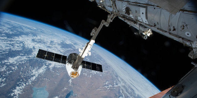 The Canadarm 2 reaches out to capture the SpaceX Dragon cargo spacecraft and prepare it to be pulled into its port on the International Space Station Friday April 17, 2015. The Canadarm2 robotic arm will maneuver Dragon to its installation position at the Earth-facing port of the Harmony module where it will reside for the next five weeks. (AP Photo/NASA)