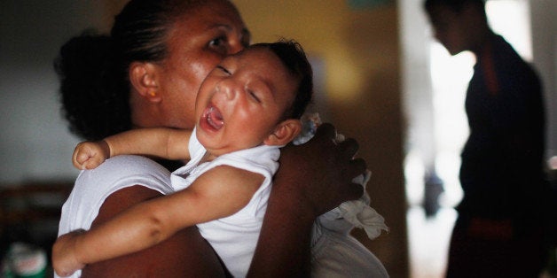 RECIFE, BRAZIL - JANUARY 31: Alice Vitoria Gomes Bezerra, 3-months-old, who has microcephaly, is held by her mother Nadja Cristina Gomes Bezerra on January 31, 2016 in Recife, Brazil. In the last four months, authorities have recorded close to 4,000 cases in Brazil in which the mosquito-borne Zika virus may have led to microcephaly in infants. The ailment results in an abnormally small head in newborns and is associated with various disorders including decreased brain development. According to the World Health Organization (WHO), the Zika virus outbreak is likely to spread throughout nearly all the Americas. (Photo by Mario Tama/Getty Images)