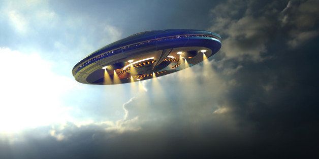 Alien UFO saucer flying on a clouds background above Earth 