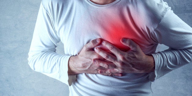 Severe heartache, man suffering from chest pain, having heart attack or painful cramps, pressing on chest with painful expression.