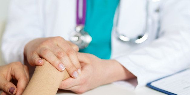 Female doctor's hands holding patient's hand for encouragement and empathy. Partnership, trust and medical ethics concept. Bad news lessening and support.