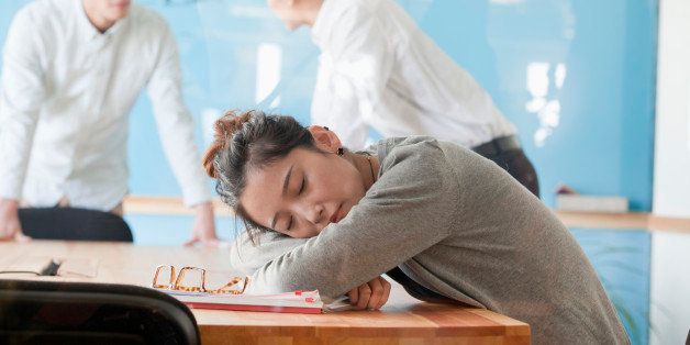 Young businesswoman sleeping during meeting