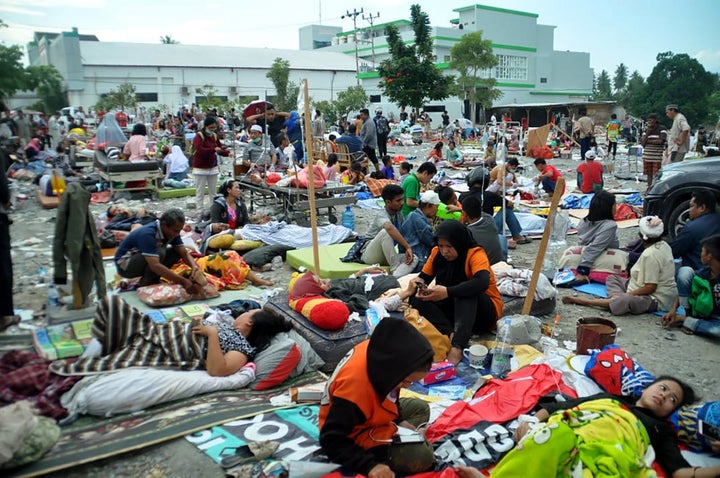 Medical team members help patients outside a hospital after an earthquake and a tsunami hit Palu, on Sulawesi island on September 29, 2018.