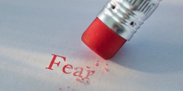 Studio shot of pencil erasing the word fear from piece of paper