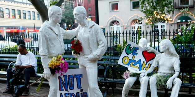 NEW YORK, NY - JUNE 12: Tribute signs are placed on statues depicting homosexual couples in a park near the Stonewall Inn whe