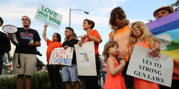 People attend a vigil in West Hollywood, California, following the early morning shooting at a gay nightclub in Orlando, Flor