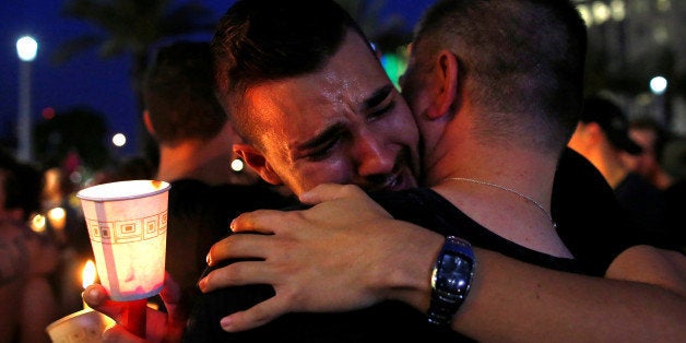 People embrace during a candlelight vigil at a memorial service for the victims of the shooting at the Pulse gay night club i