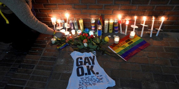 A woman places a candle at a make-shift memorial for the victims of the mass shooting at Orlando's Pulse nightclub, in Boston, Massachusetts, U.S. June 13, 2016. REUTERS/Gretchen Ertl