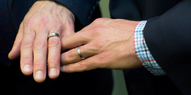 Men's hands together showing wedding rings