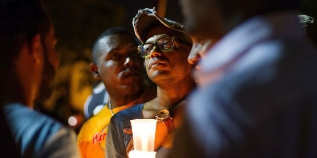 People light candles and listen to speakers at a memorial gathering for those killed in Orlando at the Colonial Zone in Santo