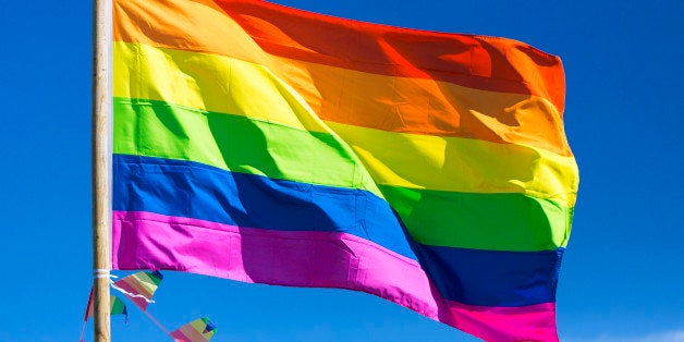 Rainbow flag against sky during gay pride parade