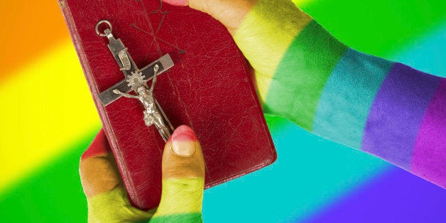 Old hands (woman) holding a very old bible, rainbow flag patternHand (woman) holding a very old bible, isolated on white, rai