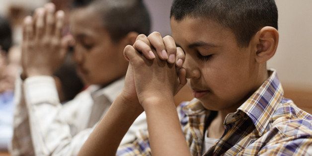 Hispanic boys praying in church