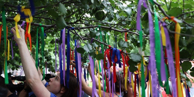 NEW YORK, NY - JUNE 16: People tie ribbons on the Survivor Tree at the National September 11 Memorial & Museum in honor of the victims of the Orlando nightclub attack on June 16, 2016 in New York City. Hundreds of people tied colored ribbons on the Survivor Tree at the National September 11 Memorial & Museum to honor the victims of the terror attack at the Pulse nightclub in Orlando over the weekend that left 49 dead. (Photo by Justin Sullivan/Getty Images)