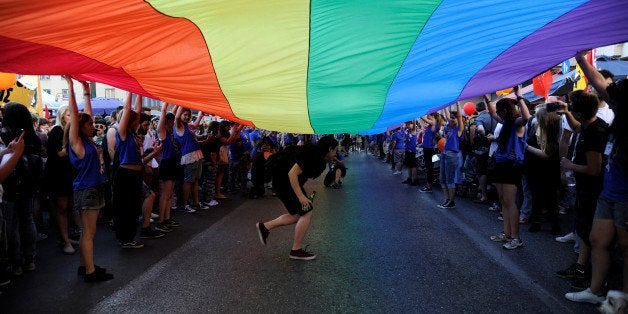 Gay rights activists raise a huge rainbow flag during a gay pride parade in Athens, June 11, 2016. REUTERS/Michalis Karagiann