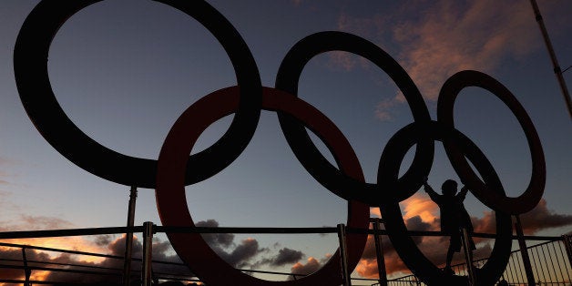 RIO DE JANEIRO, BRAZIL - AUGUST 11: A fan stands on the Olympic Rings before Nigeria takes on Spain in the Men's Basketball - Preliminary Round Group Nigeria vs Spain on Day 6 of the Rio 2016 Olympic Games at Carioca Arena 1 on August 11, 2016 in Rio de Janeiro, Brazil. (Photo by Tom Pennington/Getty Images)